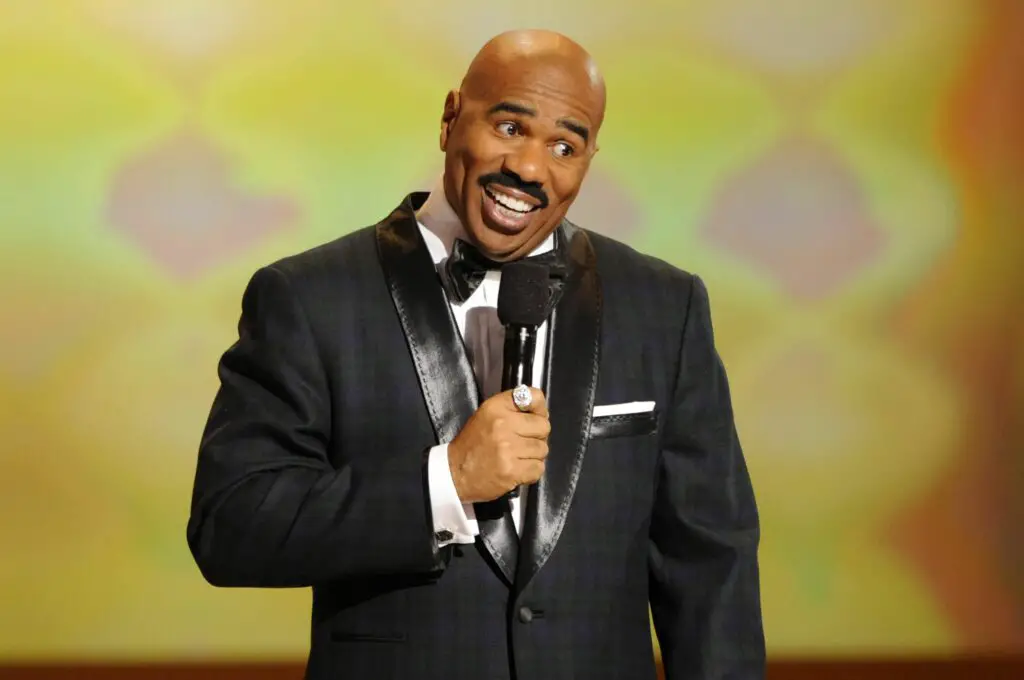 steve harvey is holding a mike.