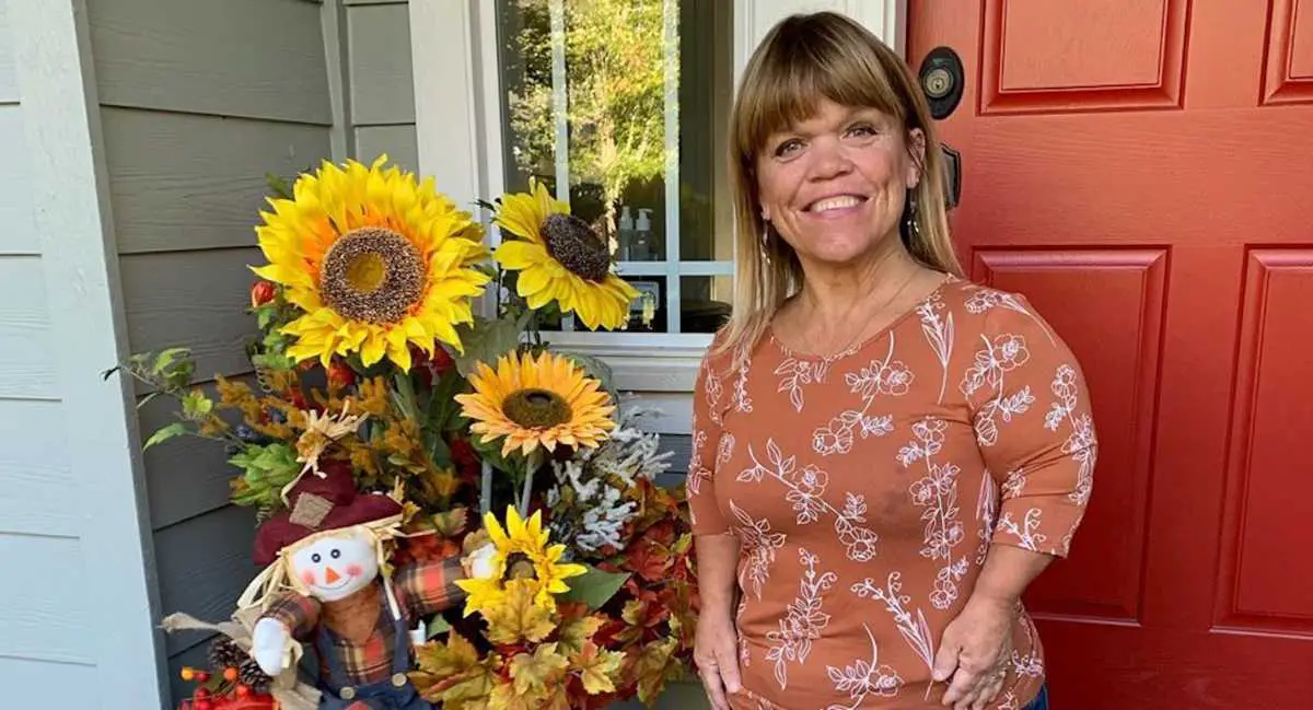 Amy Roloff posing with sunflowers