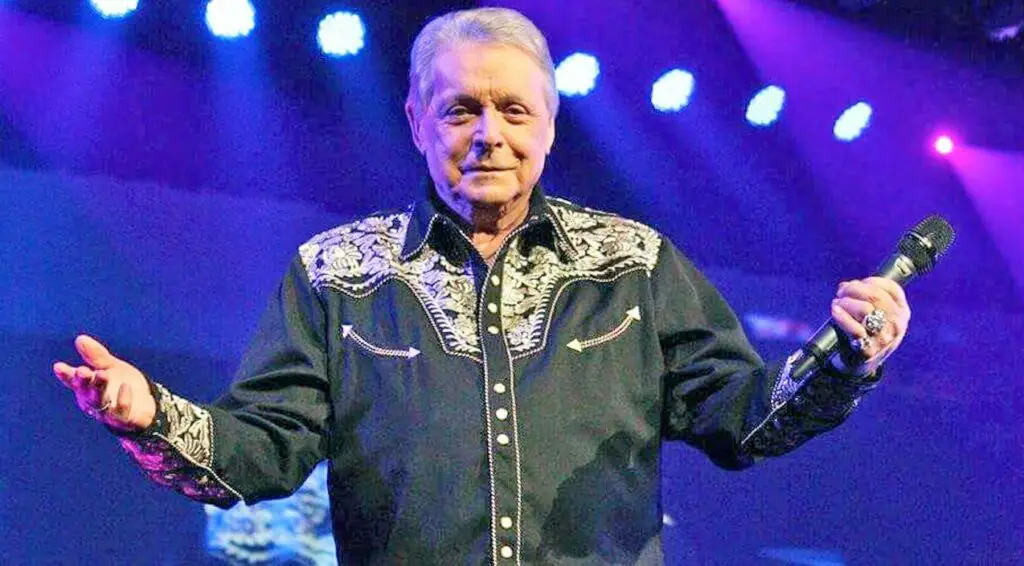 Mickey Gilley is standing on the stage 
