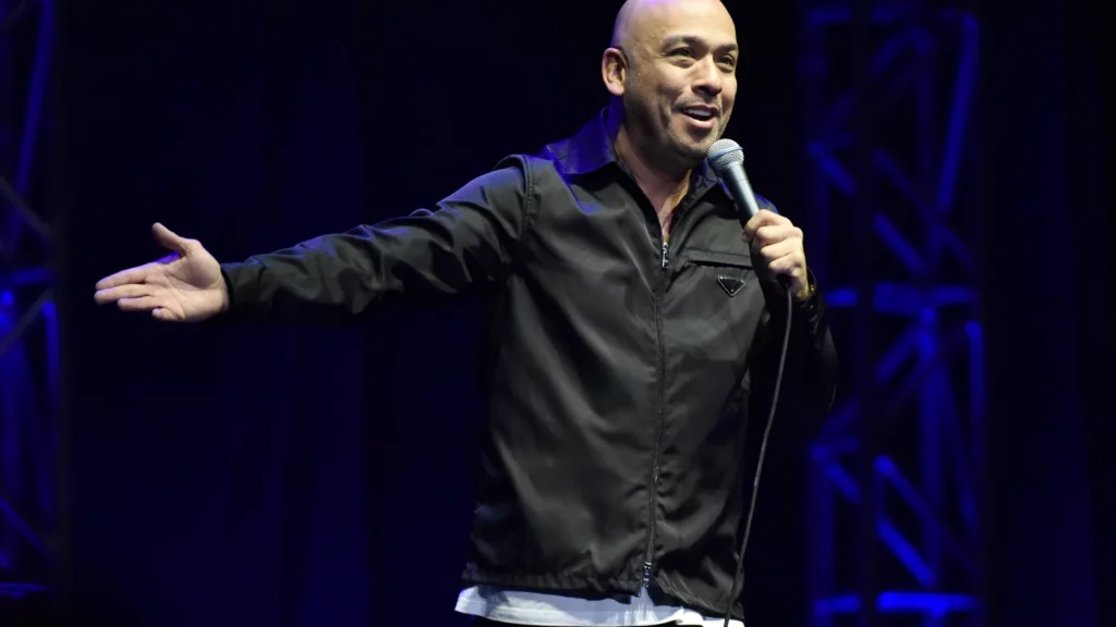 Jo Koy smiling while performing onstage